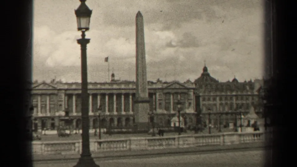 1947 Paris square view with an obelisk, tall streetlamp, formal buildings, stone railing, distant pedestrians, and scattered cars.