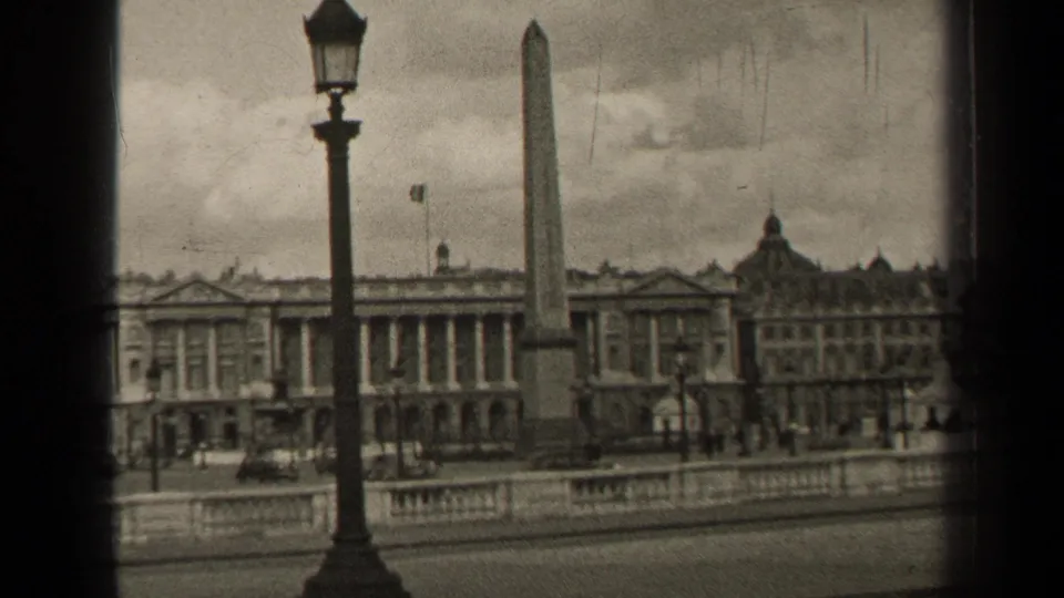 1947 Paris view of the Luxor Obelisk, formal lamppost, stone balustrade, and classical buildings in soft 8mm monochrome.