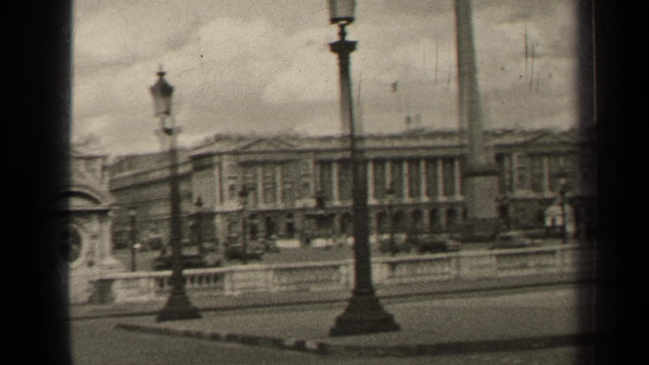 Paris plaza buildings and lampposts seen beyond a stone balustrade.