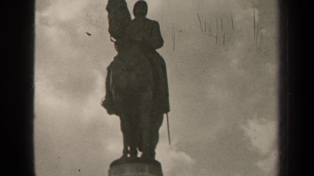1947 Paris 8mm frame with a silhouetted equestrian statue rising above its pedestal under a cloudy sky.