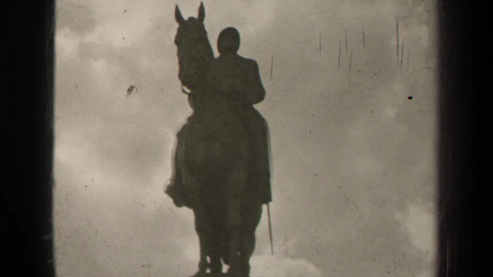 1947 Paris 8mm frame holding on the silhouetted equestrian monument, with visible film wear and cloudy sky.