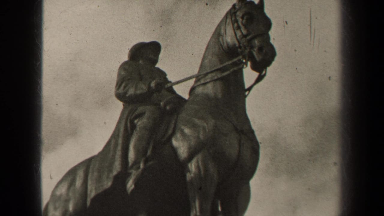 Equestrian statue with a cloaked rider on a horse, framed with dark film edges.