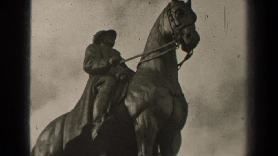 1947 Paris 8mm frame showing a weathered equestrian statue with a cloaked rider, horse reins, grain, and dark film gate borders.