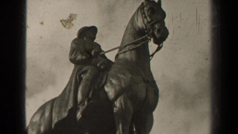 1947 Paris home-movie frame of the equestrian statue, with the rider bent forward and the horse cropped near the top edge.
