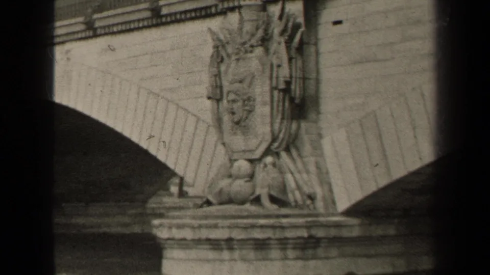 1947 Paris 8mm frame showing a historic stone bridge with arches, a sculpted pier figure, and river water below.