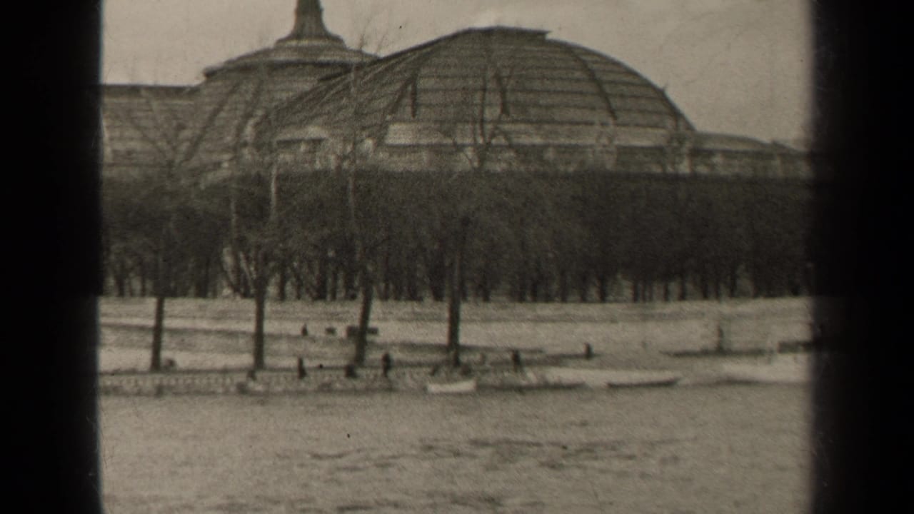 1947 Paris frame with a domed riverside building behind leafless trees, small pedestrians, and water in the foreground.