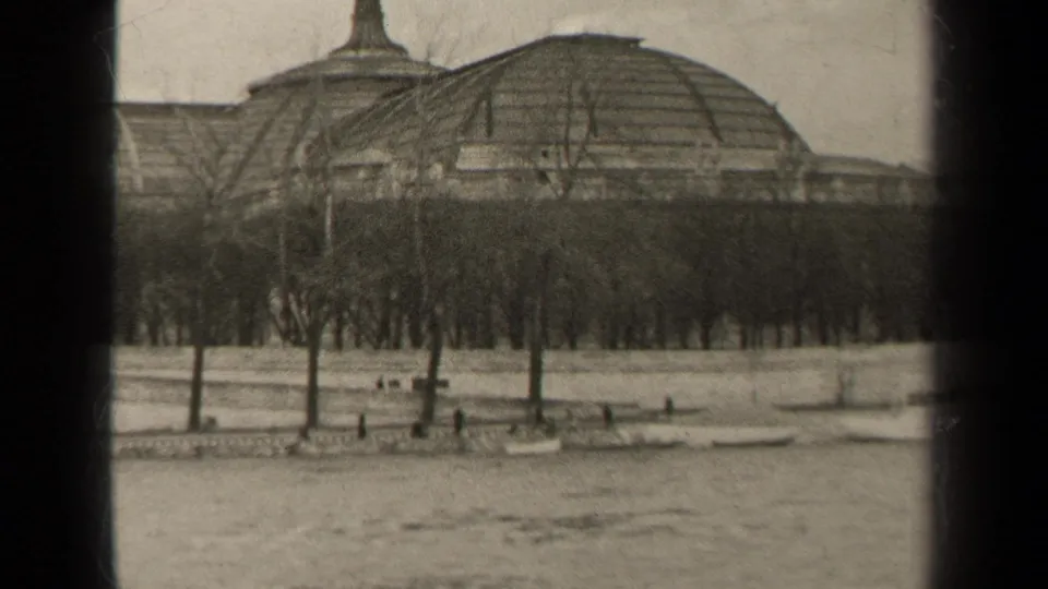 Paris home-movie frame from 1947 showing the domed building across the river, framed by bare trees and a low embankment.