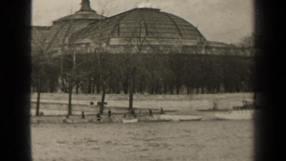 1947 Paris frame looking across the river toward a domed building, rows of bare trees, and tiny figures on the embankment.