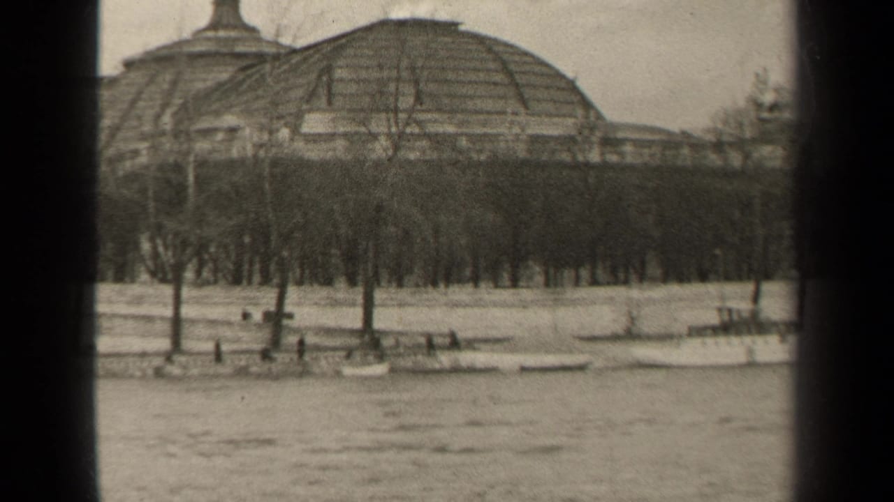 1947 Paris riverside view with small boats moored below bare trees and a large domed building beyond the bank.