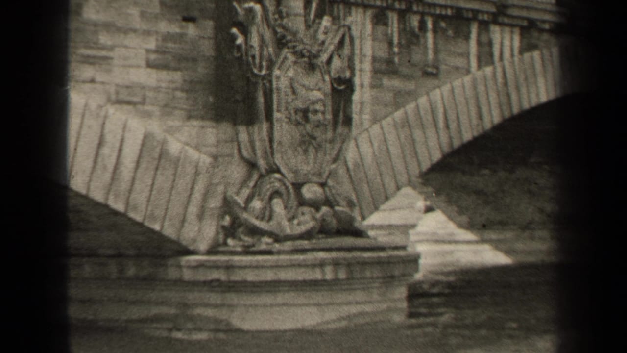 1947 Paris frame with ornate stone bridge sculpture, arched masonry, balustrade, and river below.