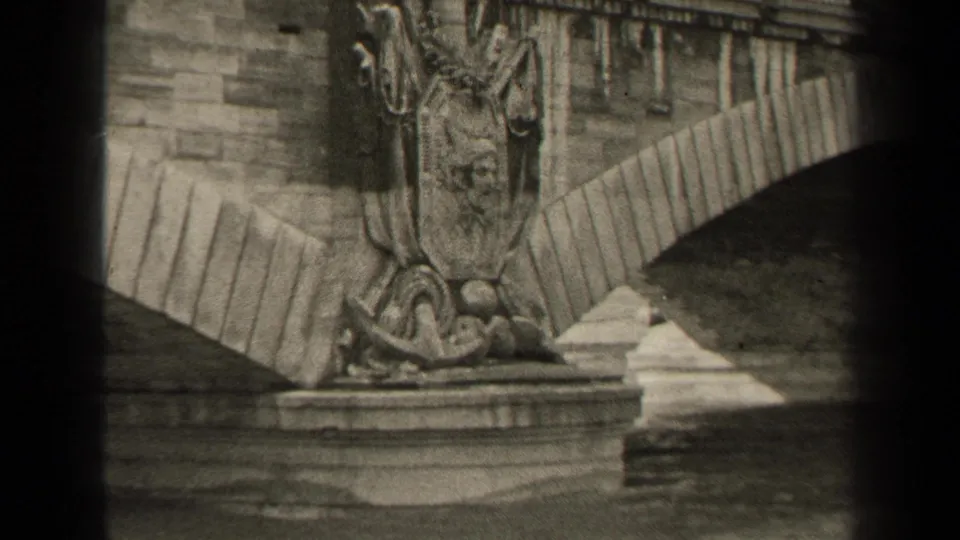 1947 Paris frame with ornate stone bridge sculpture, arched masonry, balustrade, and river below.