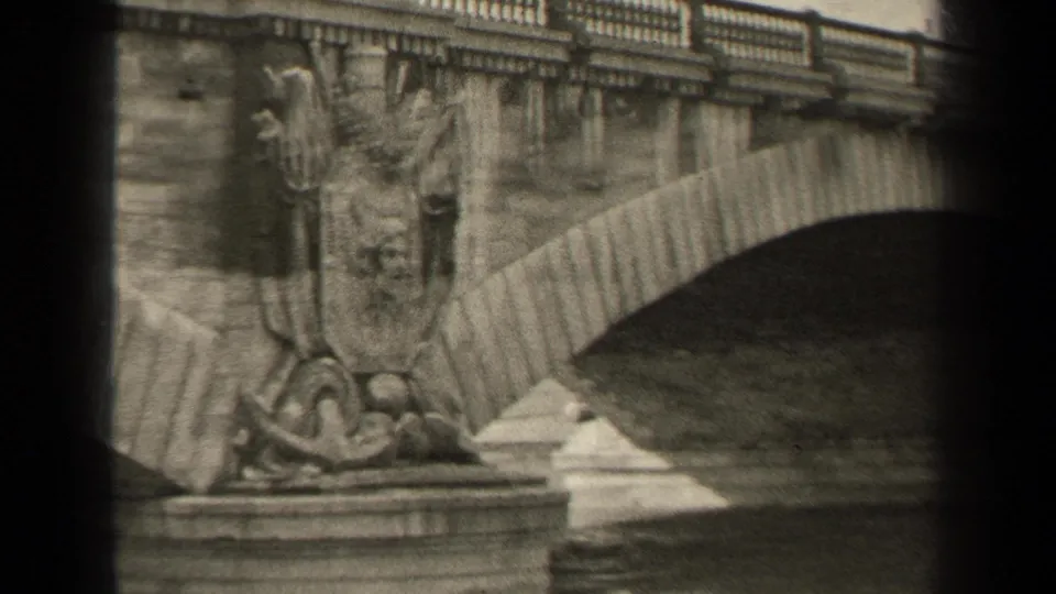 Black-and-white 1947 Paris home-movie frame centered on a carved bridge pier and arched stone span.