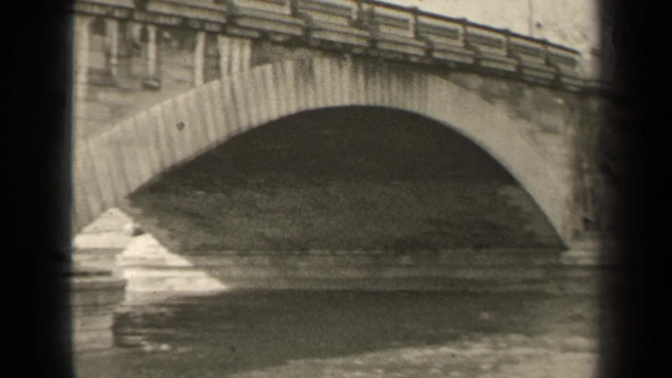 1947 Paris frame showing the bridge arch, balustrade, stone blocks, and moving river beneath.