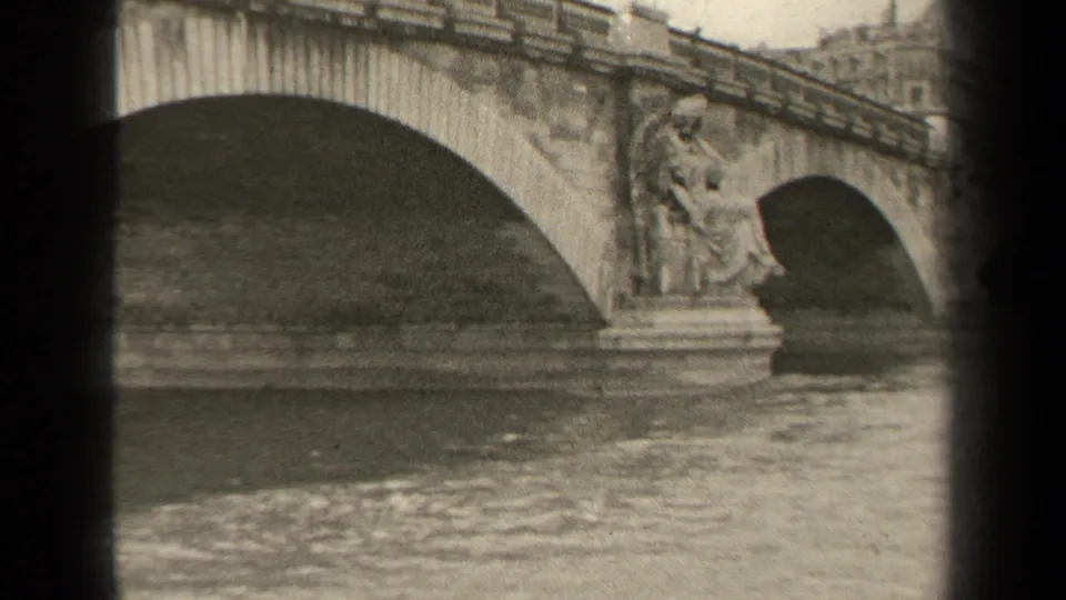 1947 Paris frame with ornate stone bridge piers, multiple arches, and gently moving river water.