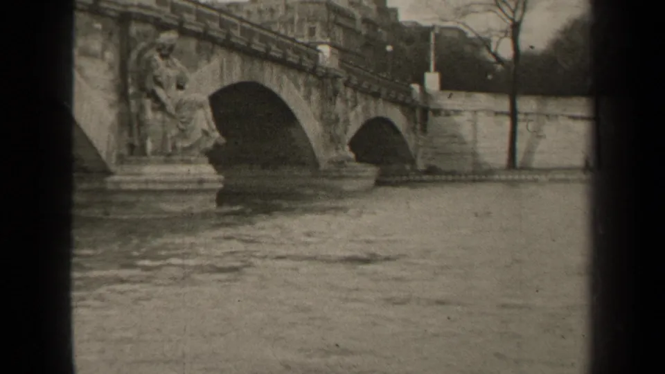 1947 Paris frame with the camera closer to the bridge, emphasizing the stone arches, sculpted figures, river, and dark edge of the film frame.