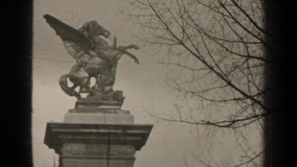Final 1947 Paris frame holds on the Pegasus-like public sculpture, with winter branches and soft 8mm grain visible.