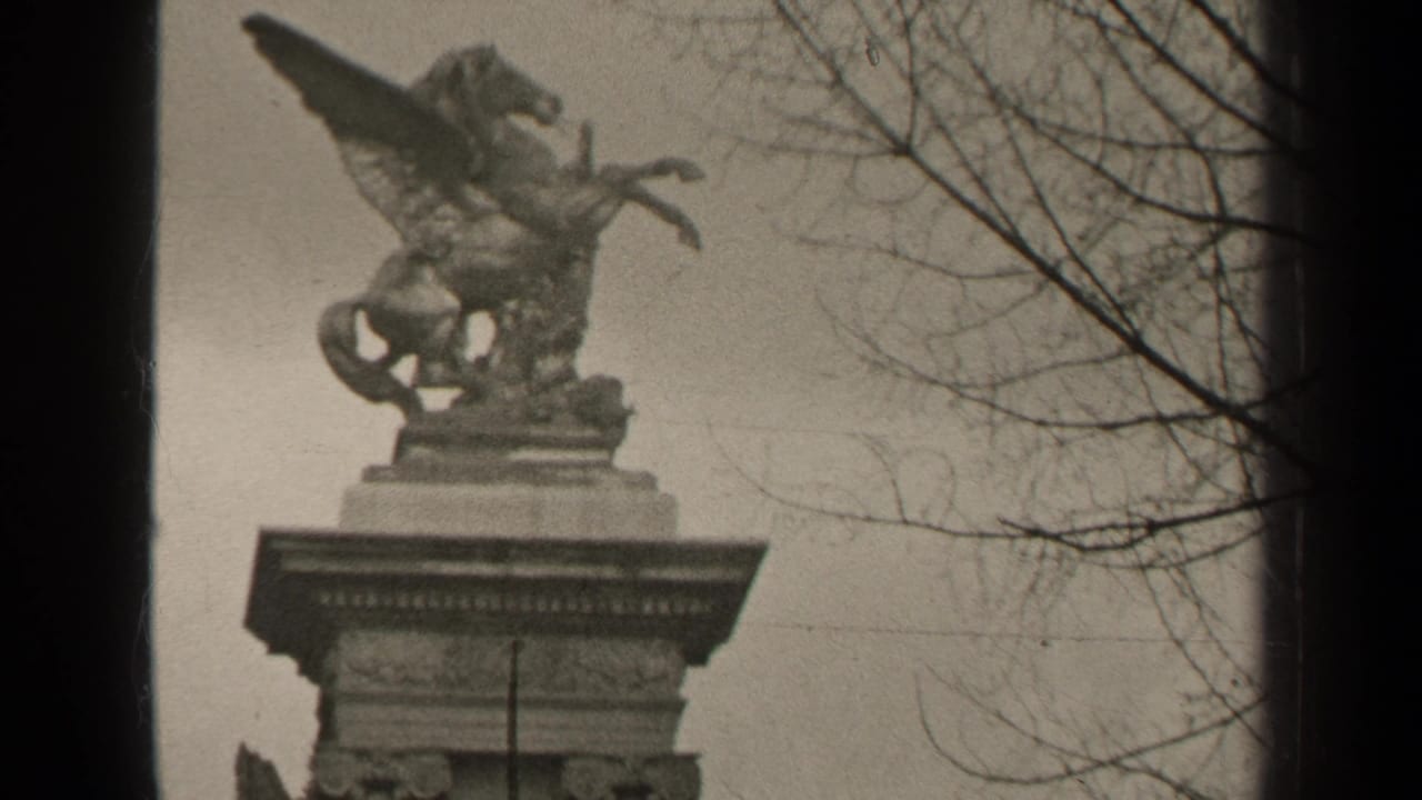 Stone column topped by a winged horse sculpture, framed by bare branches and dark film borders.