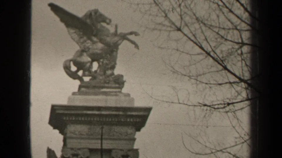 1947 Paris 8mm frame showing an ornate stone monument with a winged horse sculpture above bare winter branches.
