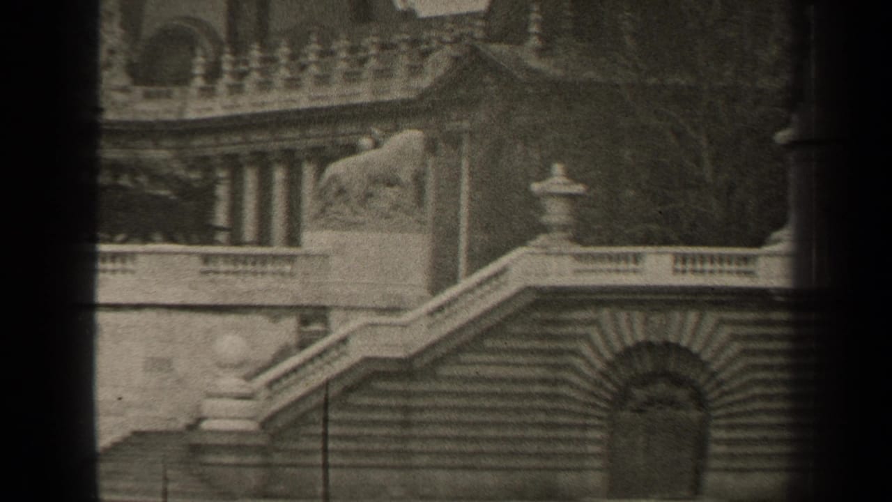 Stone staircase and balustrade with a lion statue above an arched doorway.