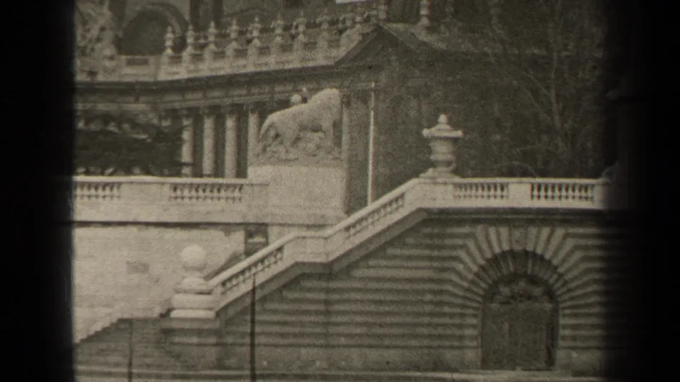 Black-and-white 8mm view in Paris, 1947, with a lion statue above stepped masonry and ornate balustrades.