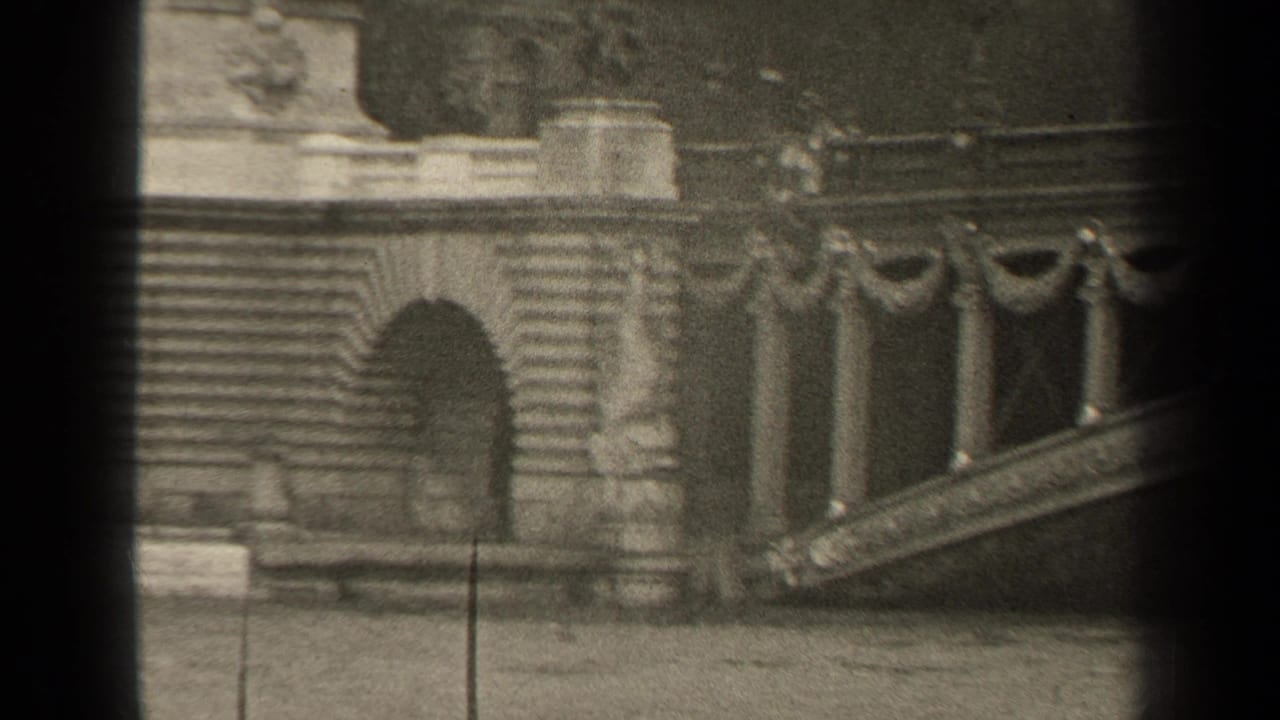 Ornate bridge railing and stone stair or abutment seen through dark film-frame borders.