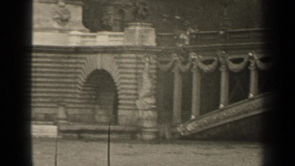 1947 Paris home-movie frame showing an ornate bridge balustrade, stonework, and dark vertical frame edges.