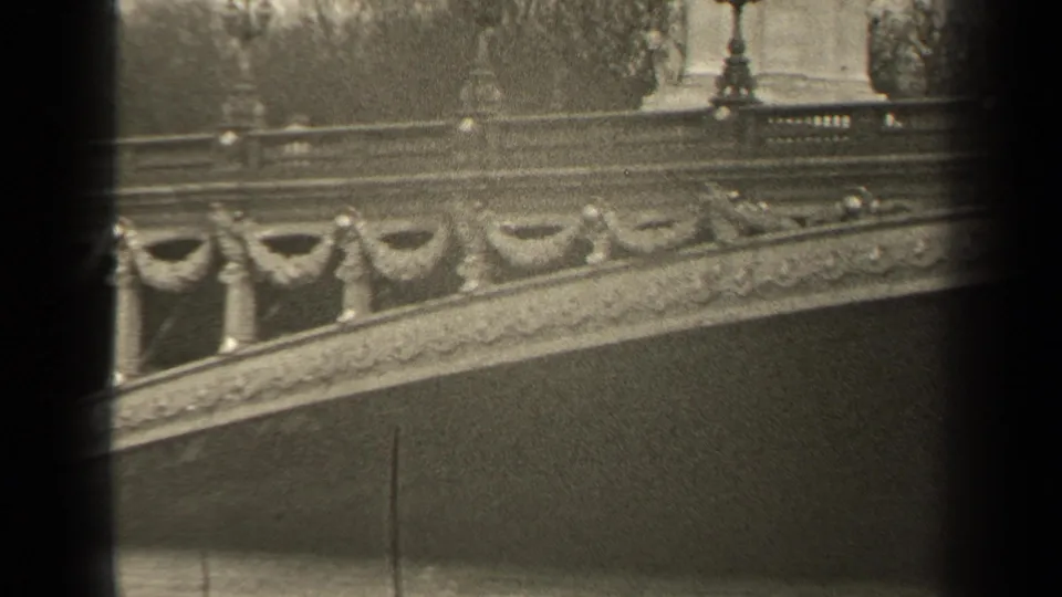 1947 Paris home-movie view of bridge railings, lampposts, and a sloped stone span across the frame.