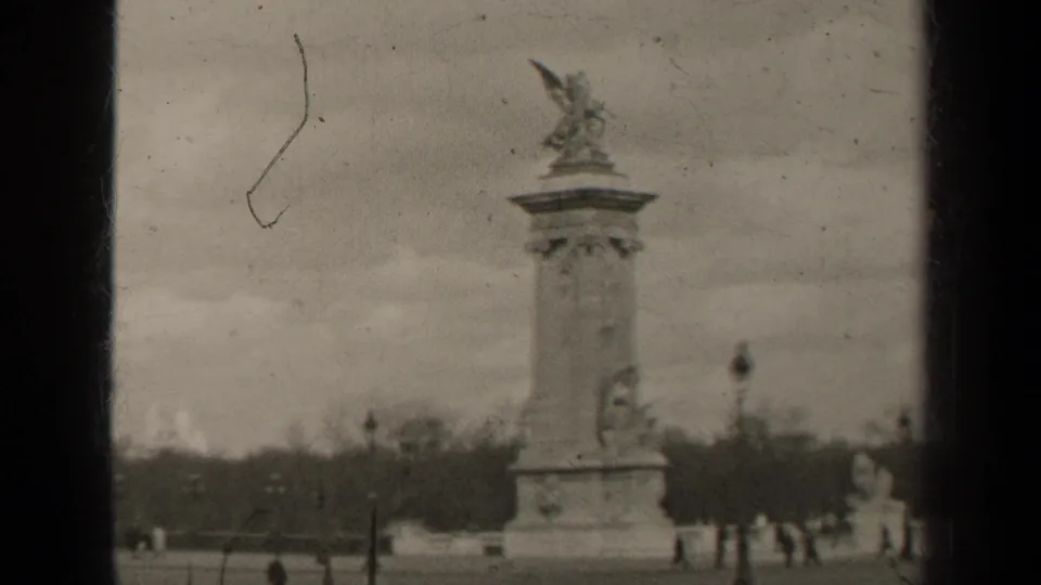1947 Paris home-movie view of the Pont Alexandre III pylon, distant people, lampposts, and riverside trees.
