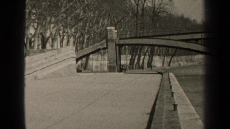 1947 Paris home-movie view of a bridge, stone embankment, bare trees, and quiet riverside walkway after the fishermen shot.
