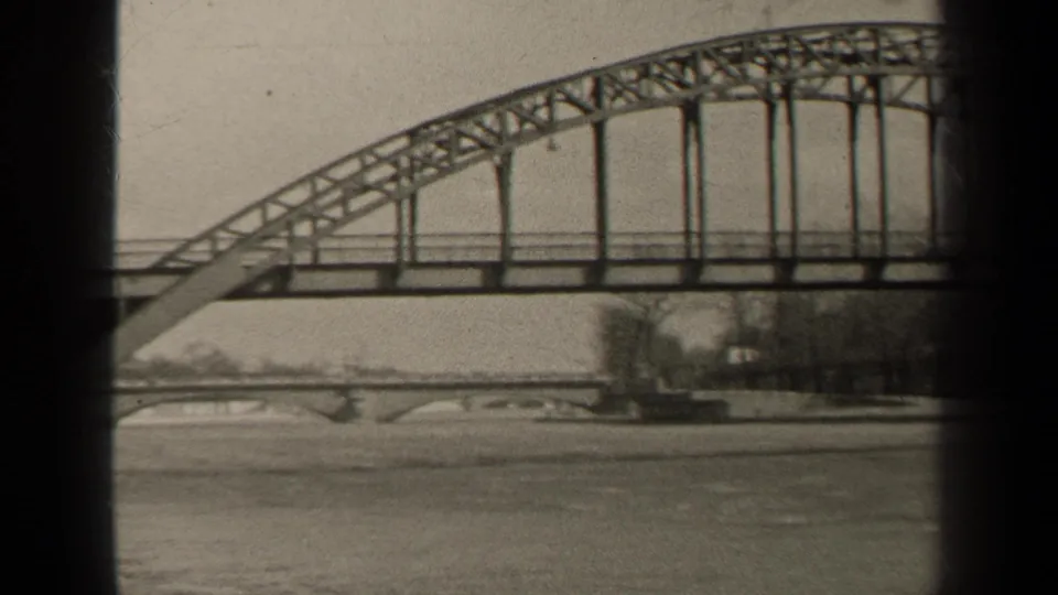 1947 Paris riverside view of a long arched bridge section, vertical supports, water below, and trees on the far bank.