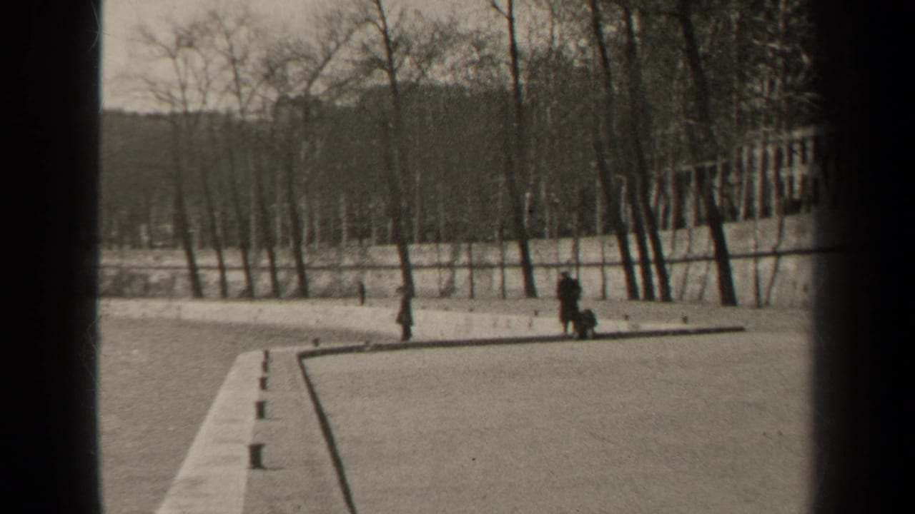 1947 Paris riverside view with pedestrians on a paved bank, bare trees, and bridge framing over a wide river.