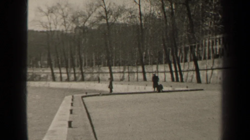 1947 Paris riverside view with pedestrians on a paved bank, bare trees, and bridge framing over a wide river.