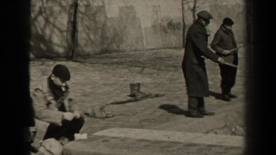 A 1947 Paris frame shows a man in a beret seated on the pavement, smoking and looking down, with two men standing nearby.