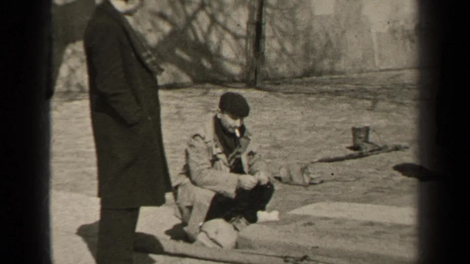 The 1947 Paris footage shows a long-coated man standing beside a beret-wearing man seated on the pavement near a wall.