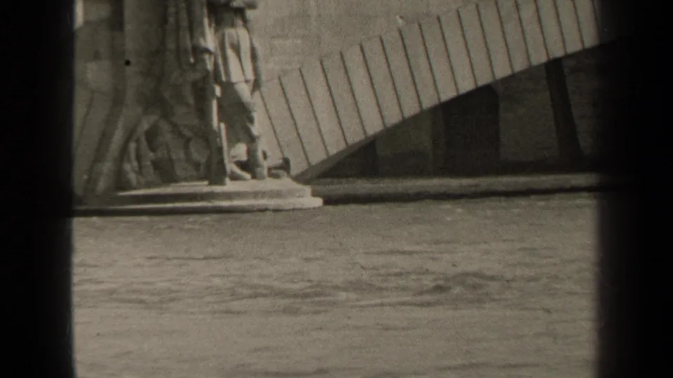 Final 1947 Paris frame holding on the statue base, water surface, and curved slatted structure behind it.