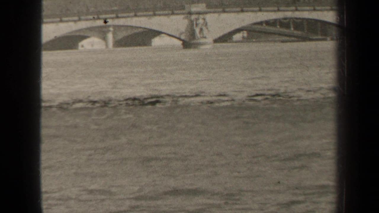 1947 Paris frame with floodwater across the foreground and stone bridge arches behind a central sculptural pier.