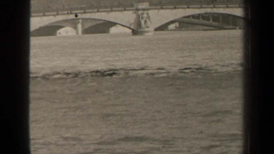 1947 Paris frame with floodwater across the foreground and stone bridge arches behind a central sculptural pier.