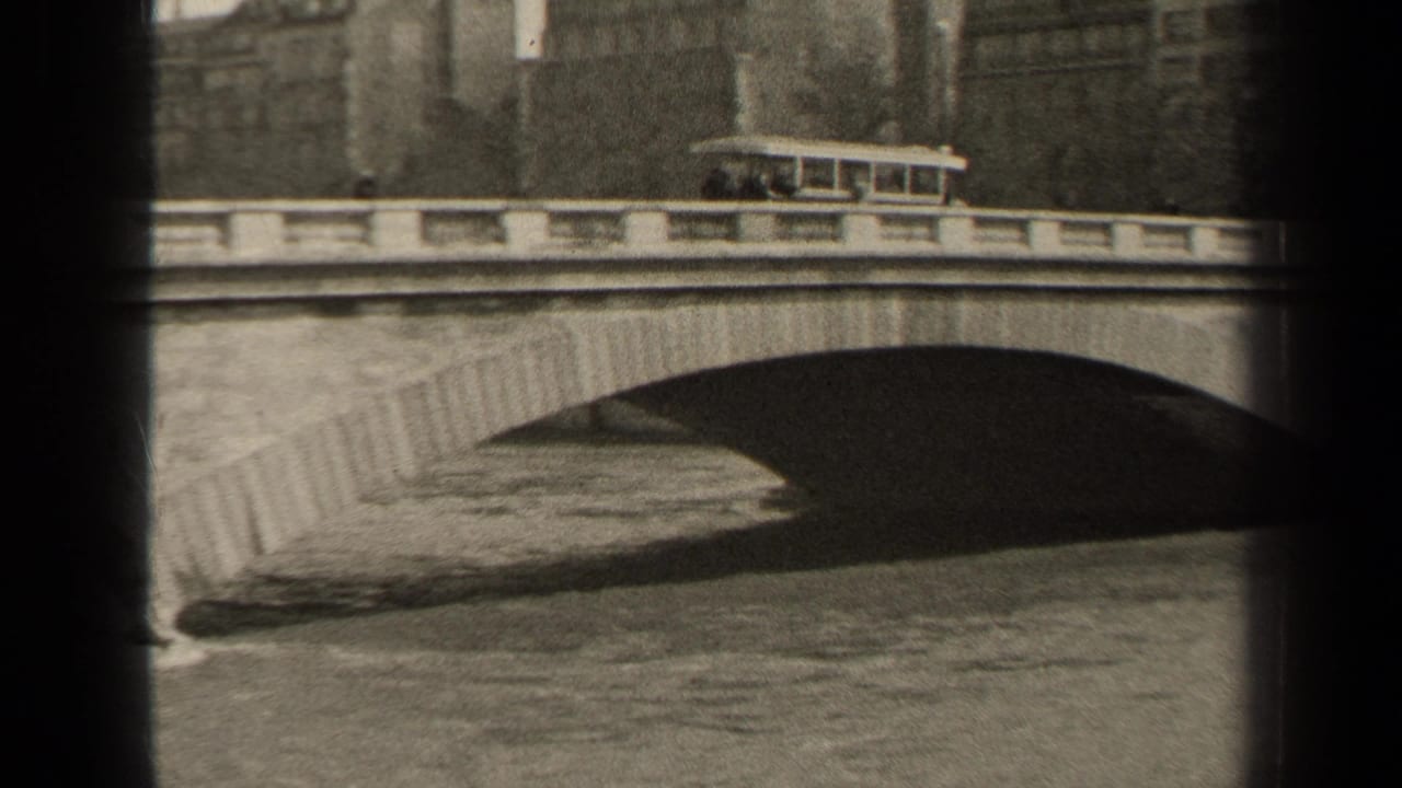 1947 Paris 8mm frame showing a trolley car on an arched masonry bridge above a waterway.