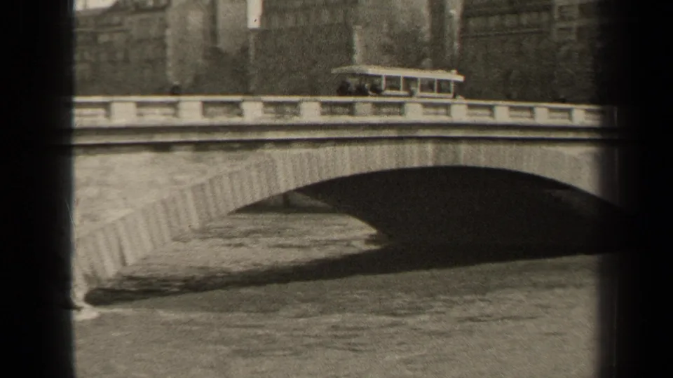 1947 Paris 8mm frame showing a trolley car on an arched masonry bridge above a waterway.
