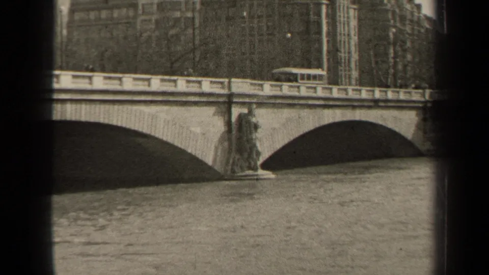 Final 1947 Paris frame showing the bridge's two arches, water below, and a trolley near the upper railing.