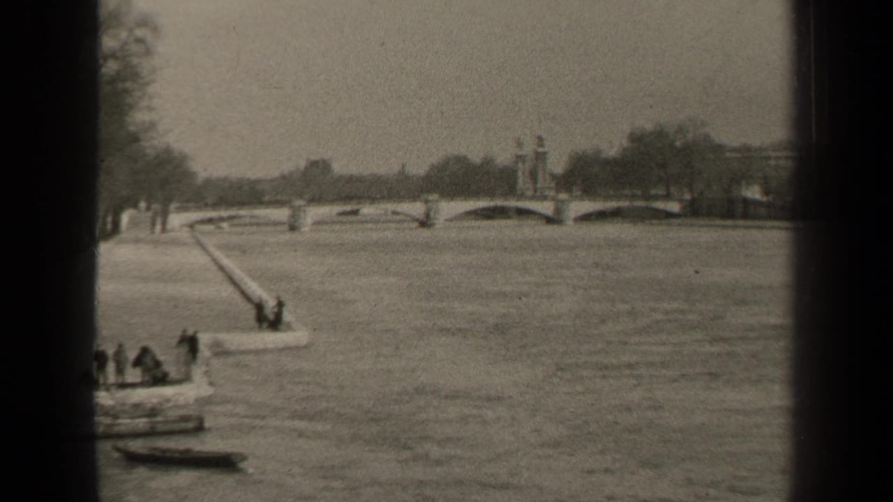 1947 Paris river view with an arched bridge, long ramp into the water, small craft, and distant people along the bank.