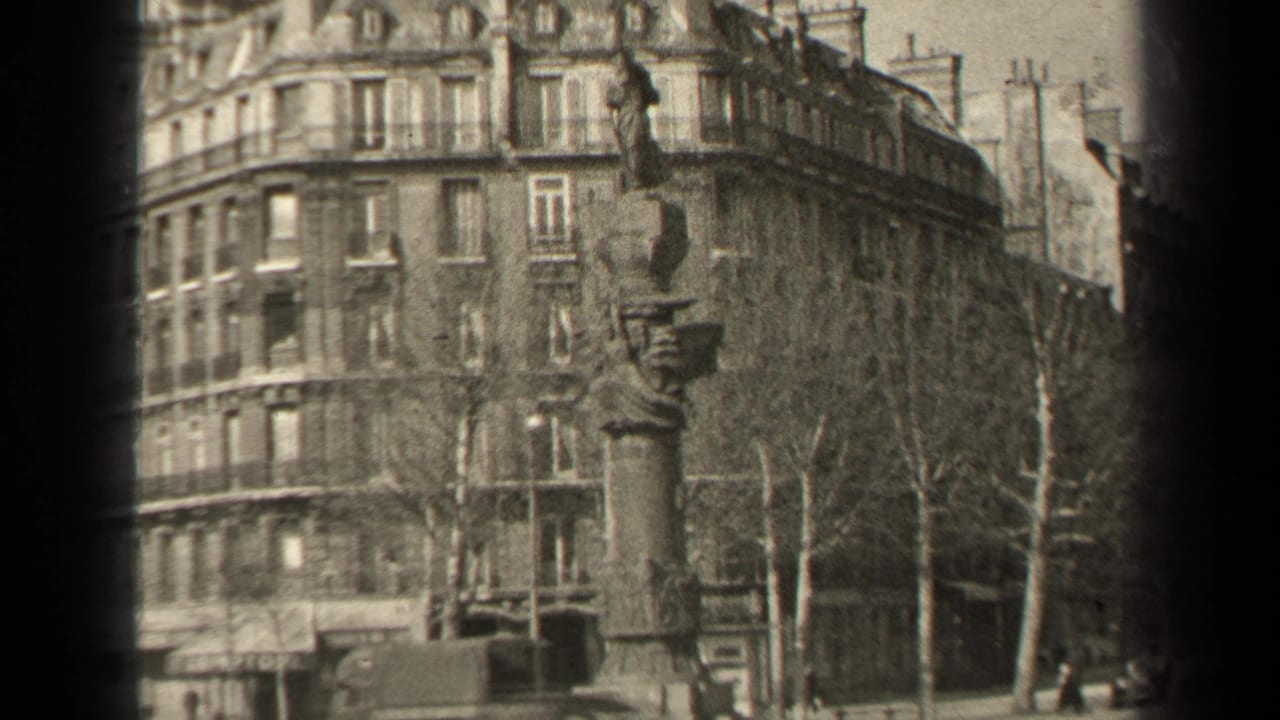 1947 Paris exterior showing a tall stone monument before a residential facade, with leafless trees and older vehicles along the street.