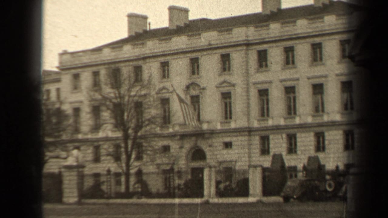 1947 Paris exterior view of a formal multi-story building, partly framed by dark film edge, with a U.S. flag and parked cars visible.