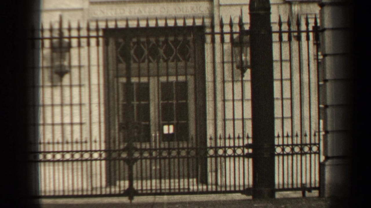 1947 Paris frame with ornate iron railings crossing a pale stone facade and a recessed barred window.
