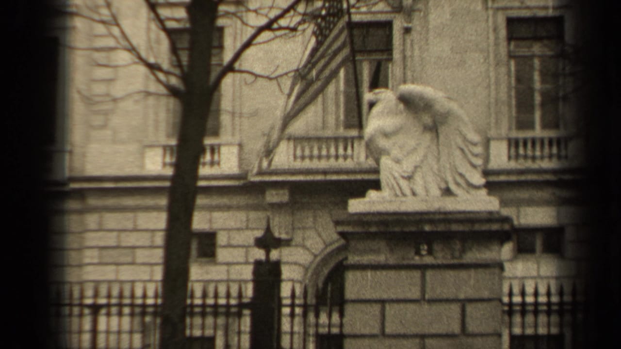Stone eagle statue and building facade seen through dark 8mm frame edges.