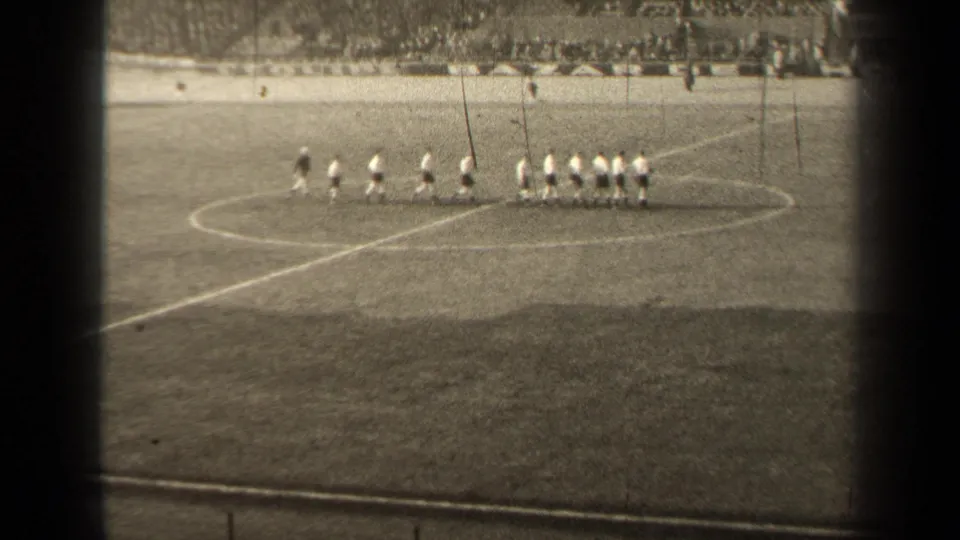 The team appears to form up near the center circle during a 1947 Paris football warm-up, seen from a distant spectator angle.