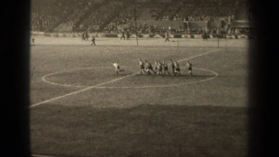 1947 Paris soccer footage with players starting to spread from the center circle while the stadium crowd remains in view.