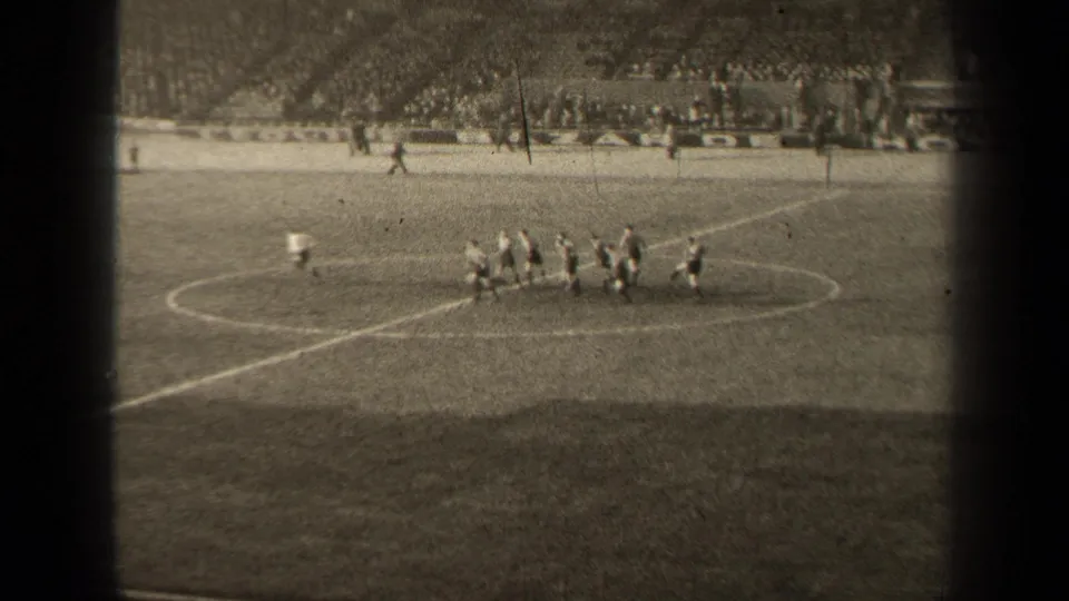 1947 Paris football match view from the stands, with players grouped near midfield and a crowd visible beyond the pitch.