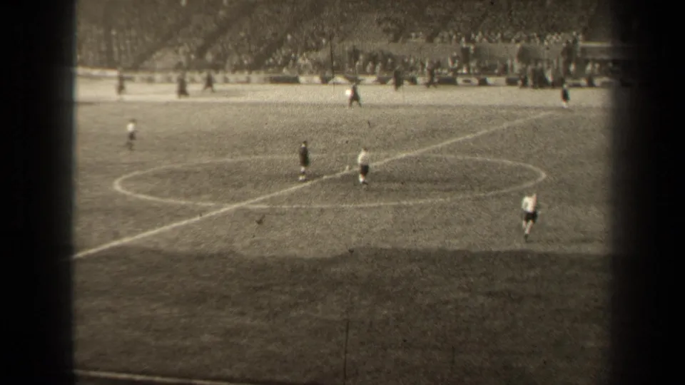 Wide 8mm stadium view in Paris, France, showing football players spread around the center circle during a 1947 match.