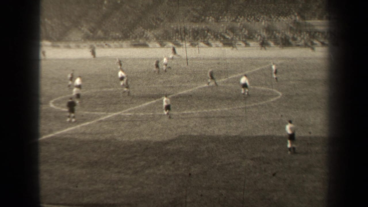 Football players gather near midfield on a marked grass pitch.
